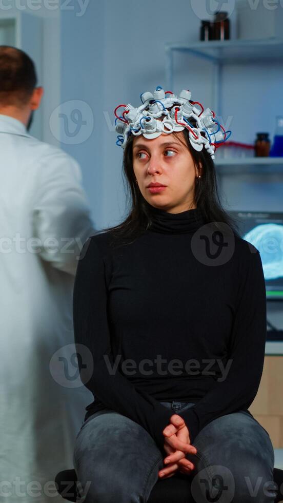 Expert medic in neuroscience developing brain experiment holding laptop explaning to woman side effects of nervous system treamtment. Team of scientists working in neurological research laboratory photo