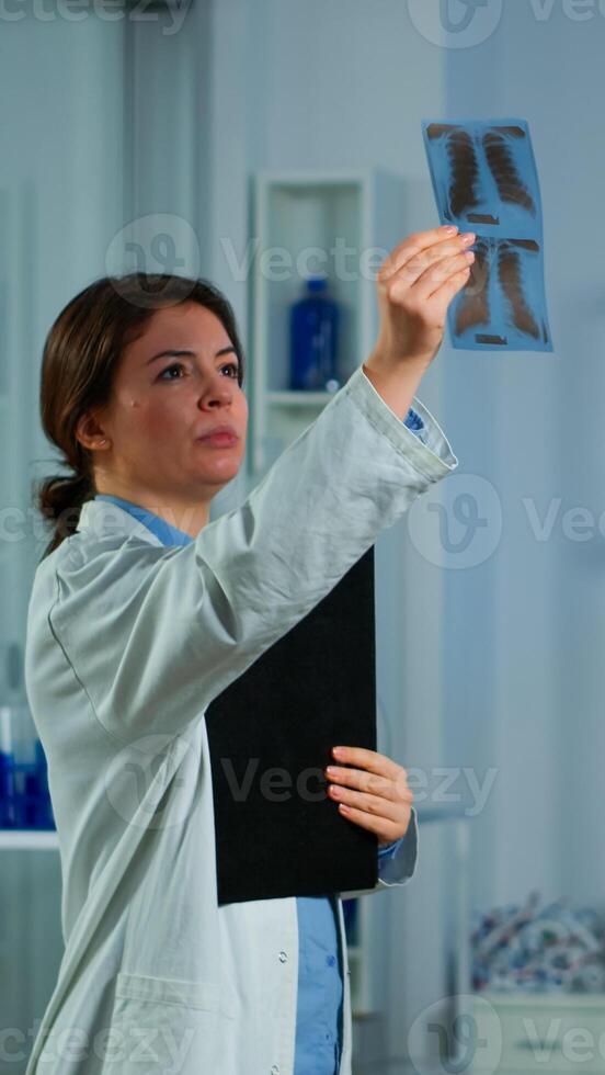 Team of doctor researchers monitoring endurance of man performance sports wearing mask running cross trainer. Lab science doctor measuring vo2 of sportsman, looking at x-ray explaning health status photo