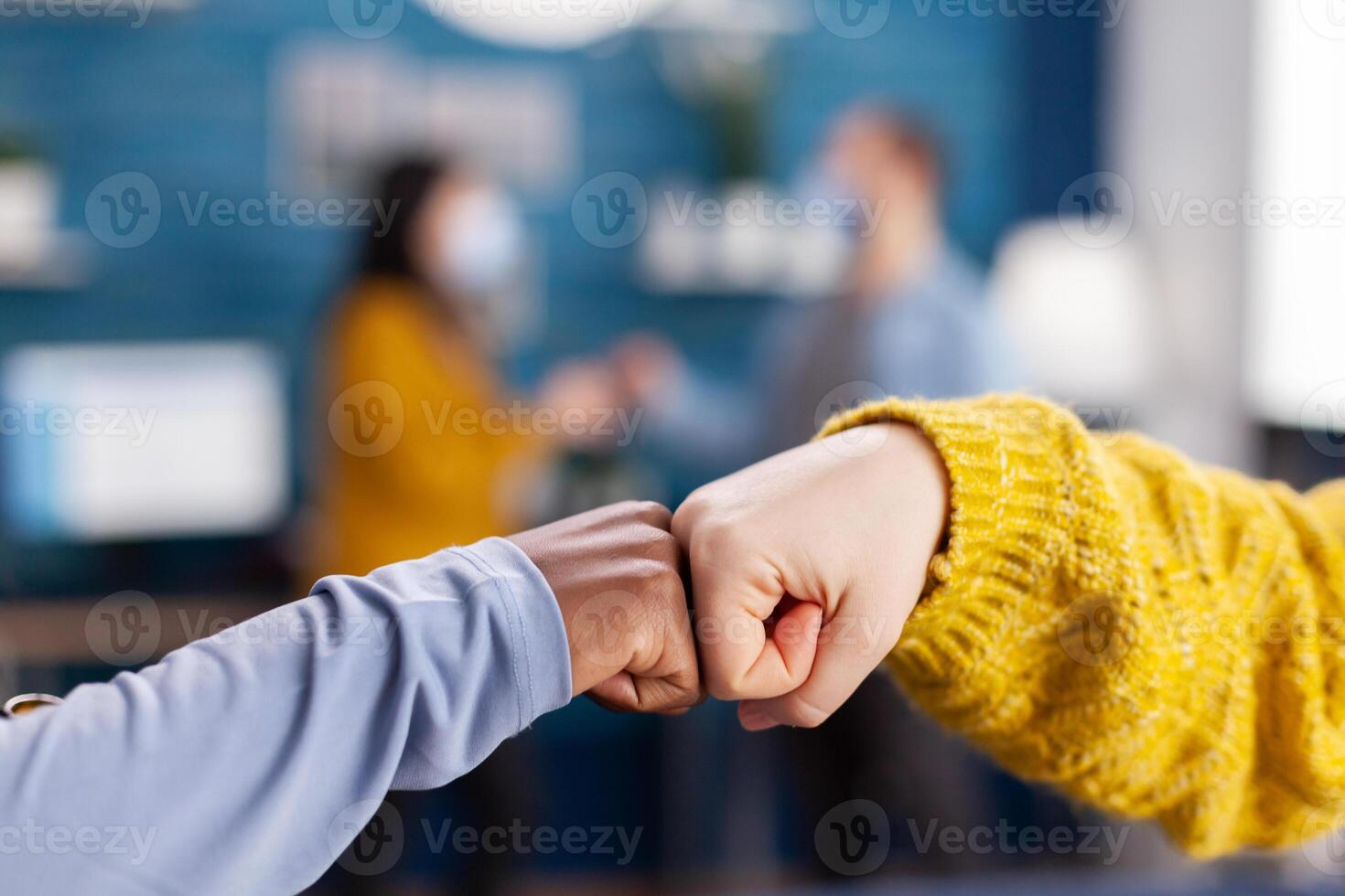 Close up of african woman and friend doing fist bump greeting each other in home living room, keeping social distancing as safety precaution during global pandemic with coronavirus. photo