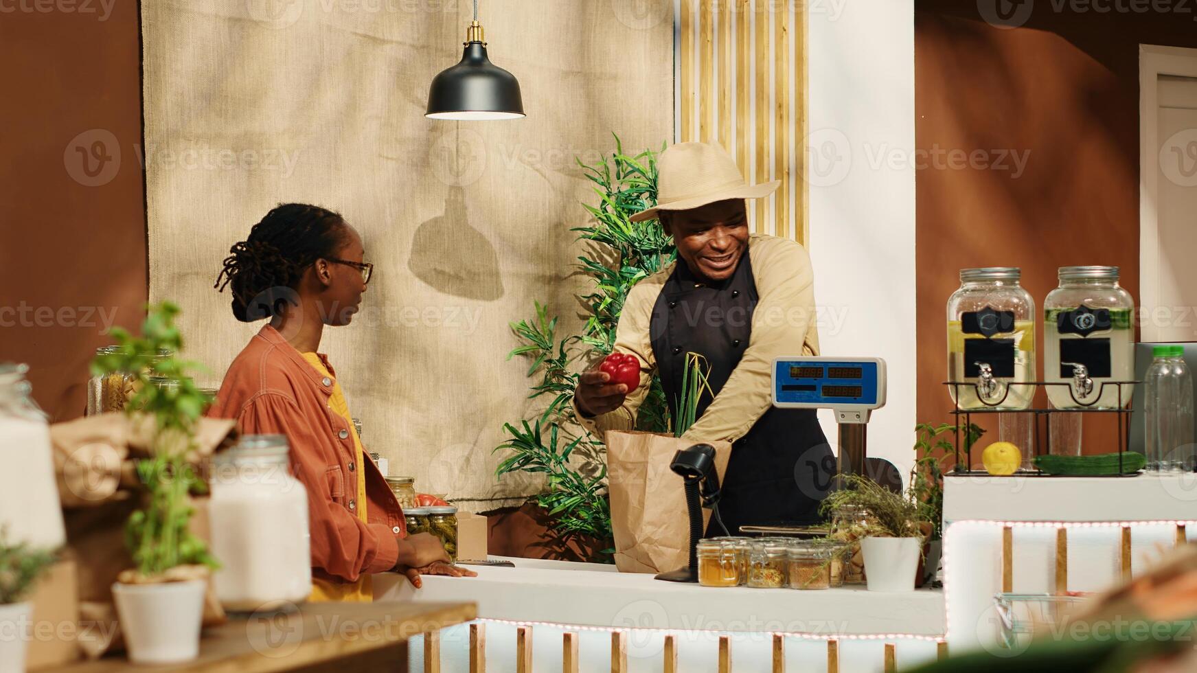 Vegan woman approaching checkout counter to buy produce, choosing organic freshly harvested fruits and vegetables at farmers market. Customer talking to merchant about healthy nutrition. Camera 1. photo