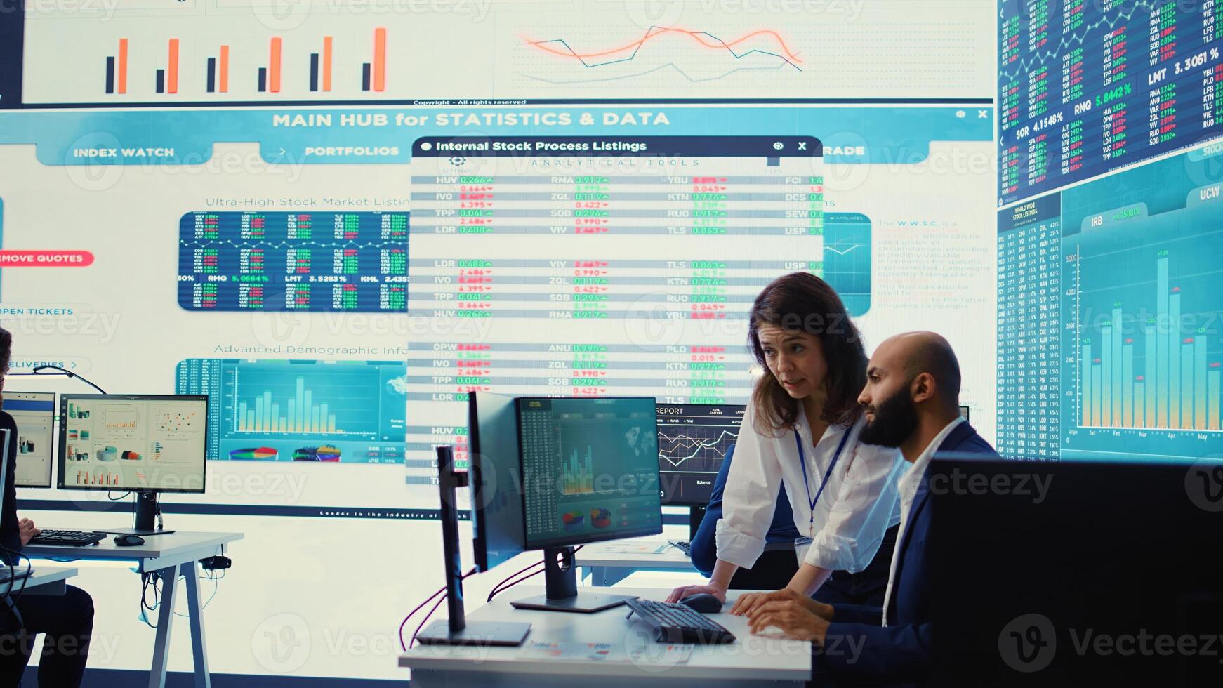 Teammates examining statistics and infographics on computer in control room, joining forces to gather insight for business development. Analysts discussing legal changes. Camera B. photo