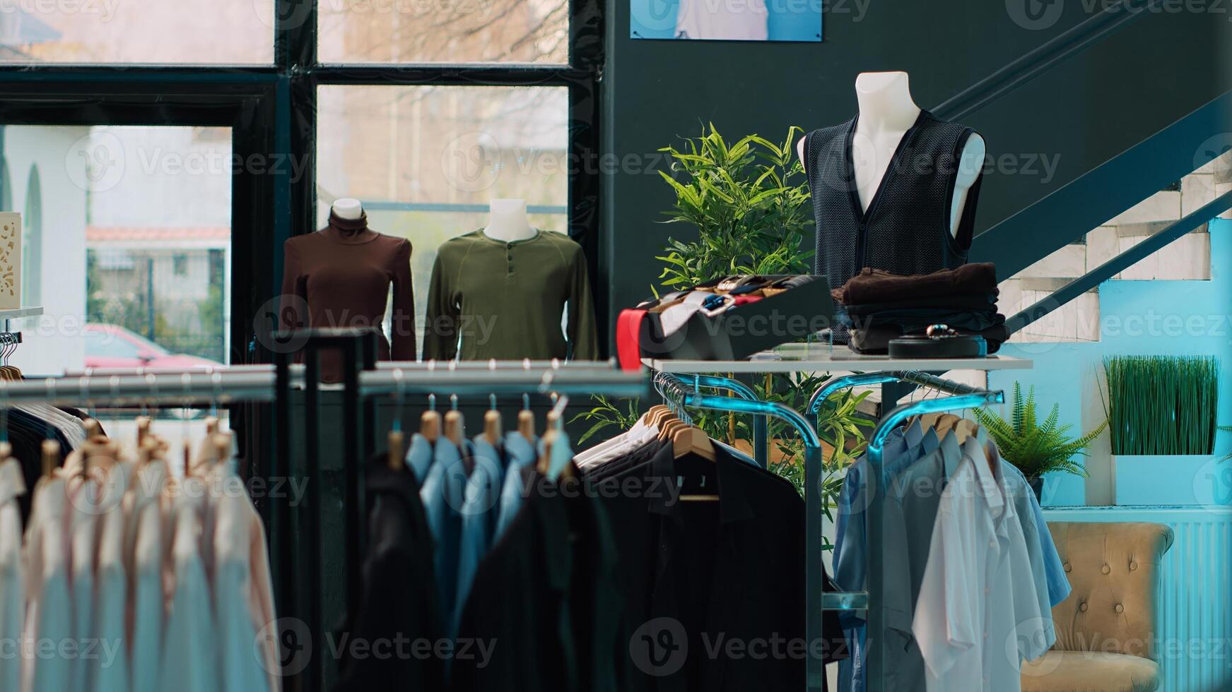 Shopping mall prepared with stock of new fashion collection line, multiple racks with fashionable wear and modern accessories. Empty clothes showroom with trendy items, small business. Camera A. photo