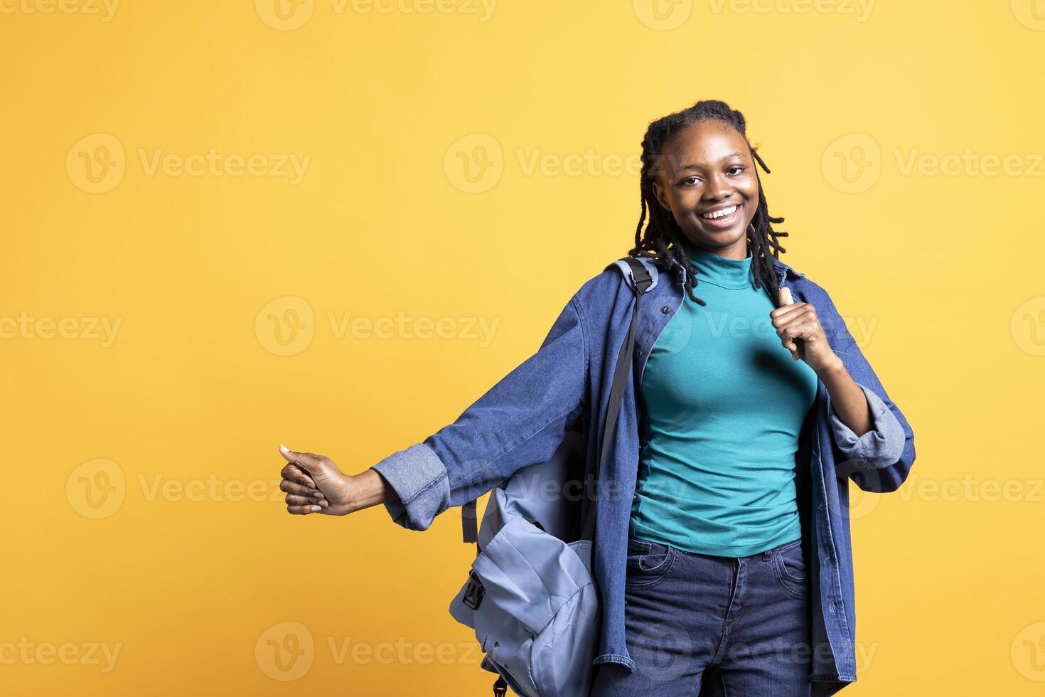 Smiling african american teenager having fun, dancing on rhythm, enjoying leisure time. Jolly BIPOC girl entertaining herself doing funky movements on music, studio background photo