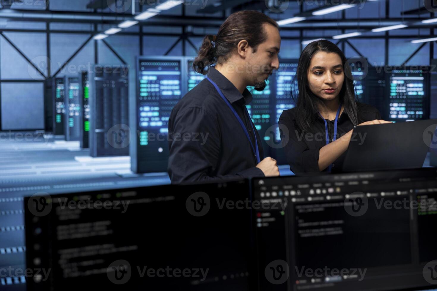 Software developers in data center running system diagnostic tests on laptop to fix problems. IT staff members deploying and error checking utilities on notebook to fix network issues performance photo