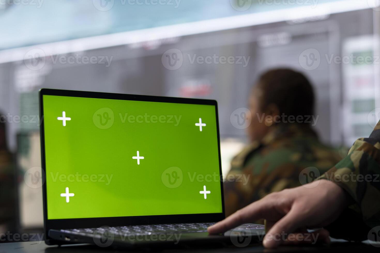 Trooper utilizing chroma key mockup screen on a laptop in military headquarters, providing real time data to ensure national safety. High ranking serviceman uses pc with copy space display. photo