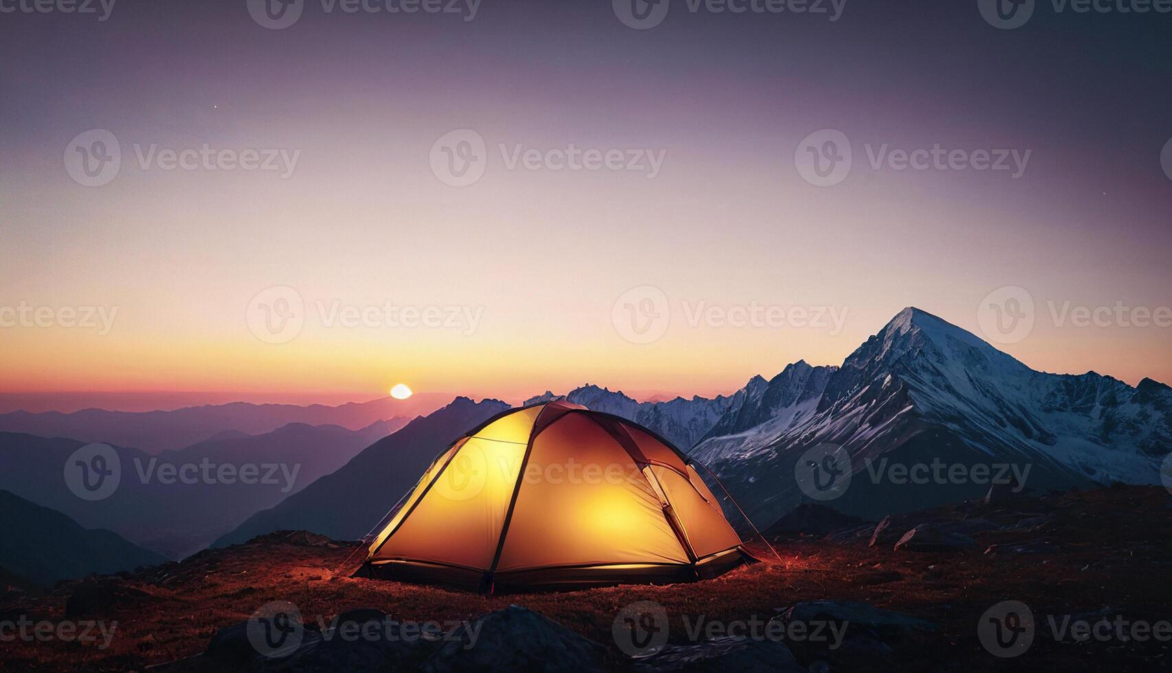 glowing tent against the backdrop of dawn and mountains photo