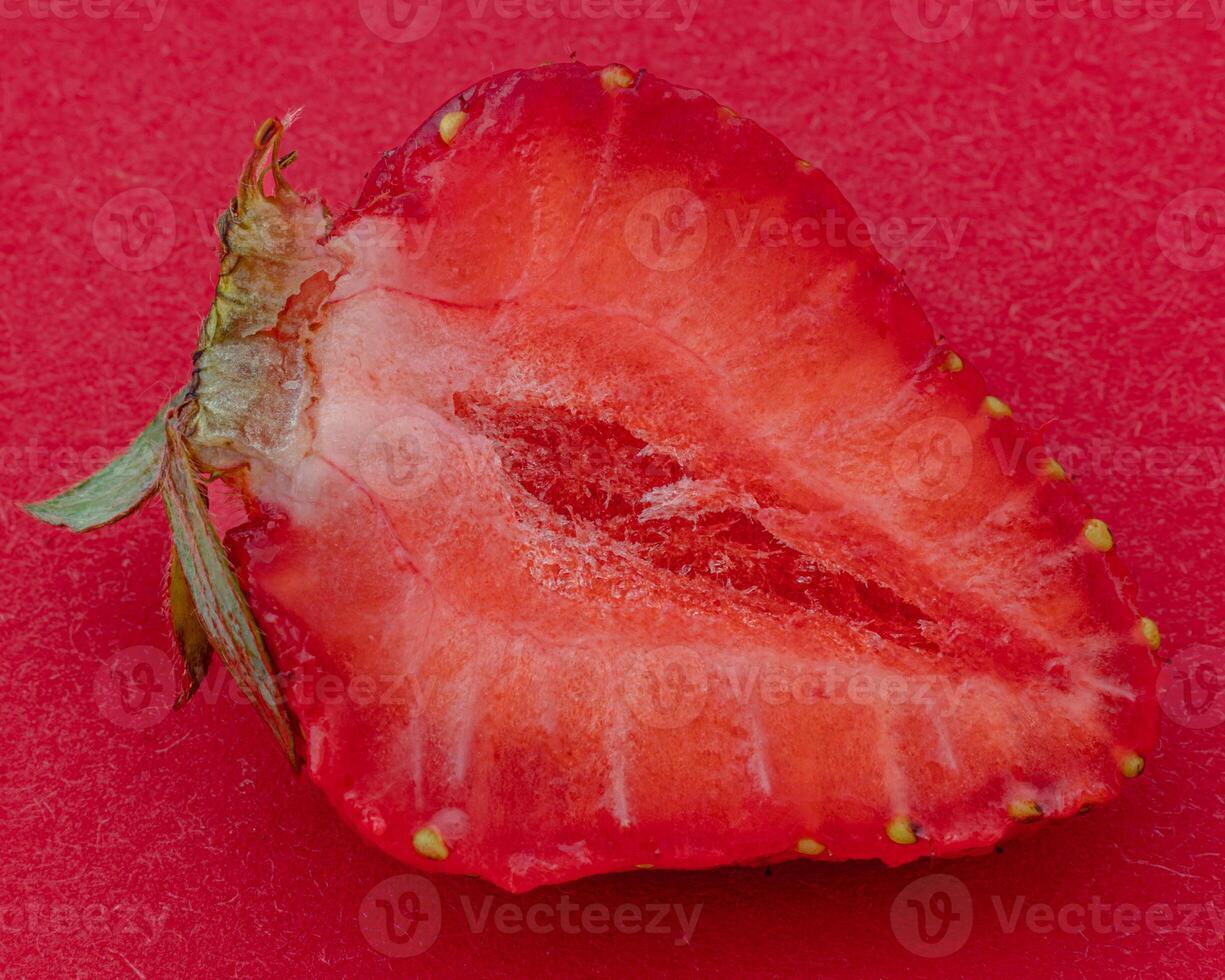 Cut ripe strawberry on red background macro shot photo