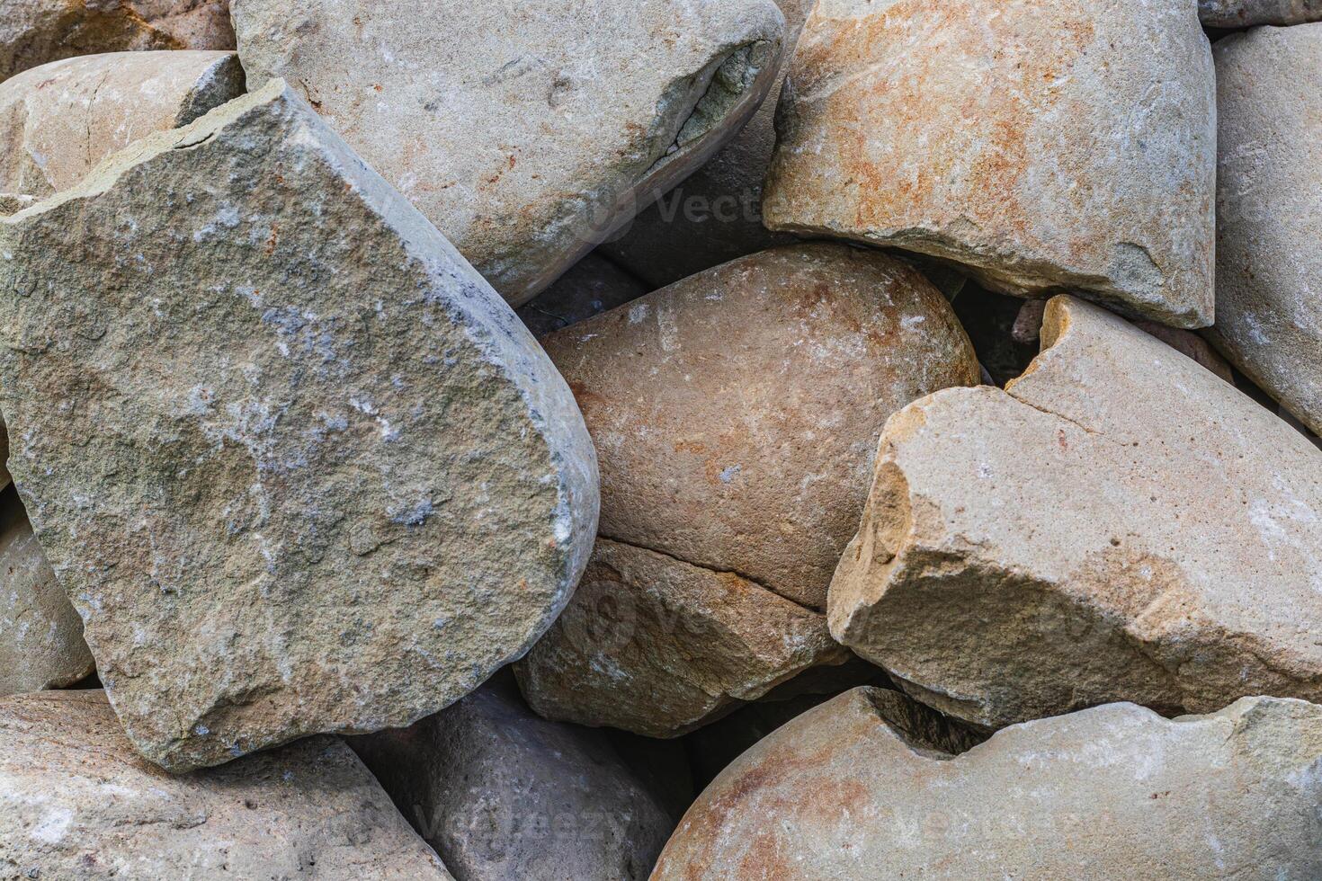Closeup of smooth river rocks displaying a variety of warm tones photo
