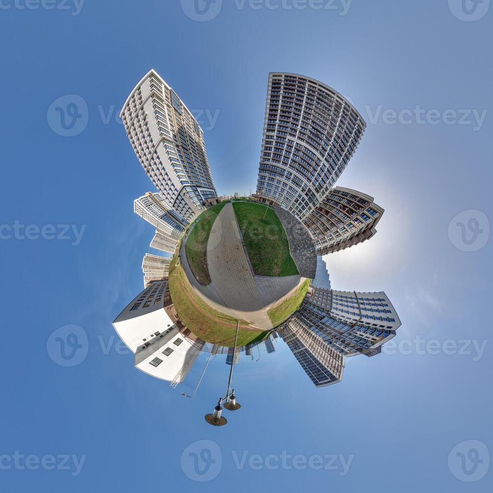 abstract swirling tiny planet spherical panorama of multi-storey buildings of skyscrapers of a residential complex in the form of a butterfly in blue sky photo