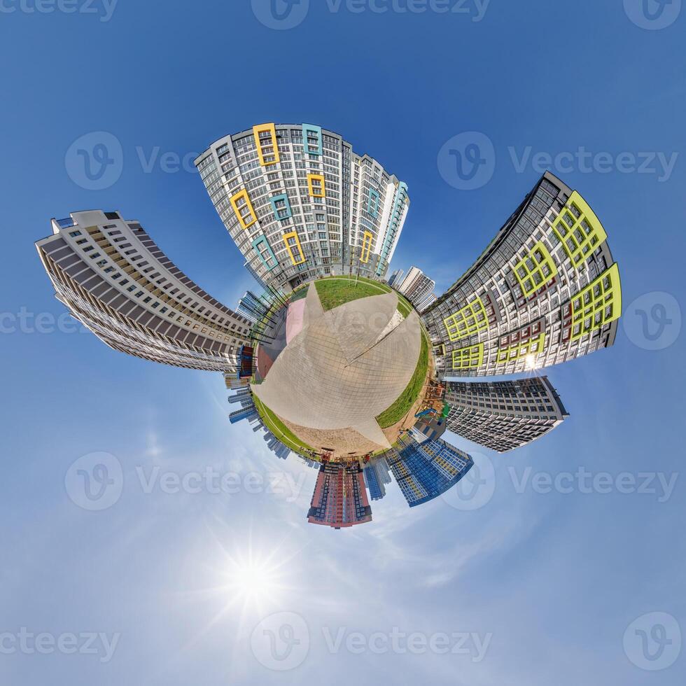 abstract swirling tiny planet spherical panorama of multi-storey buildings of skyscrapers of a residential complex in the form of a butterfly in blue sky photo