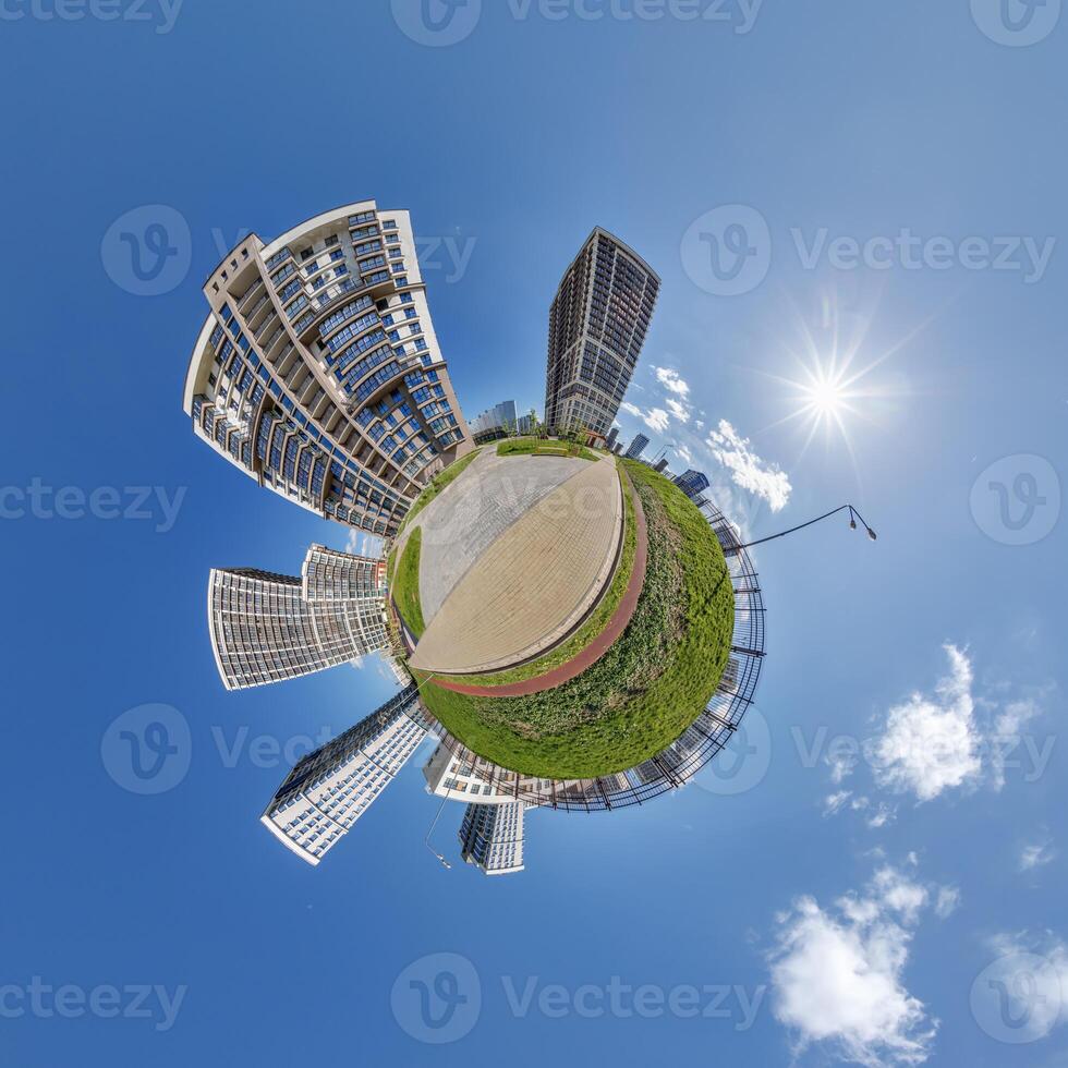 abstract swirling tiny planet spherical panorama of multi-storey buildings of skyscrapers of a residential complex in the form of a butterfly in blue sky photo