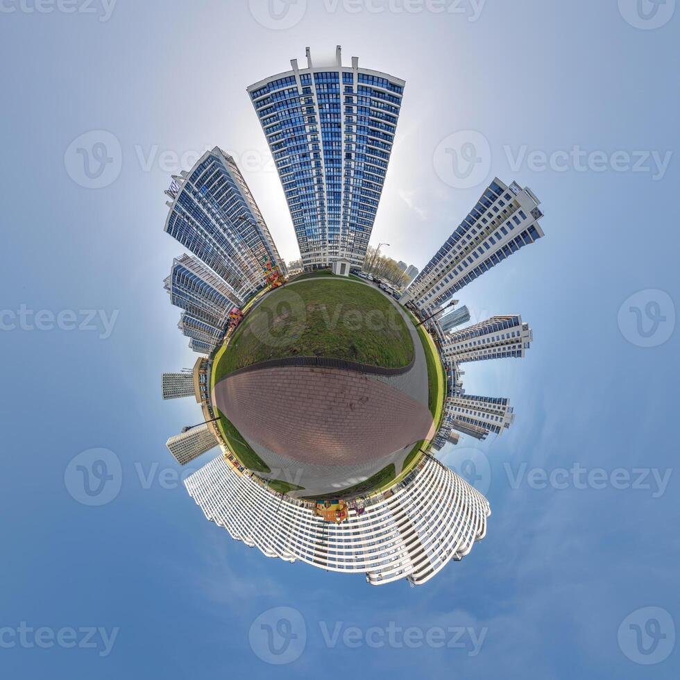abstract swirling tiny planet spherical panorama of multi-storey buildings of skyscrapers of a residential complex in the form of a butterfly in blue sky photo
