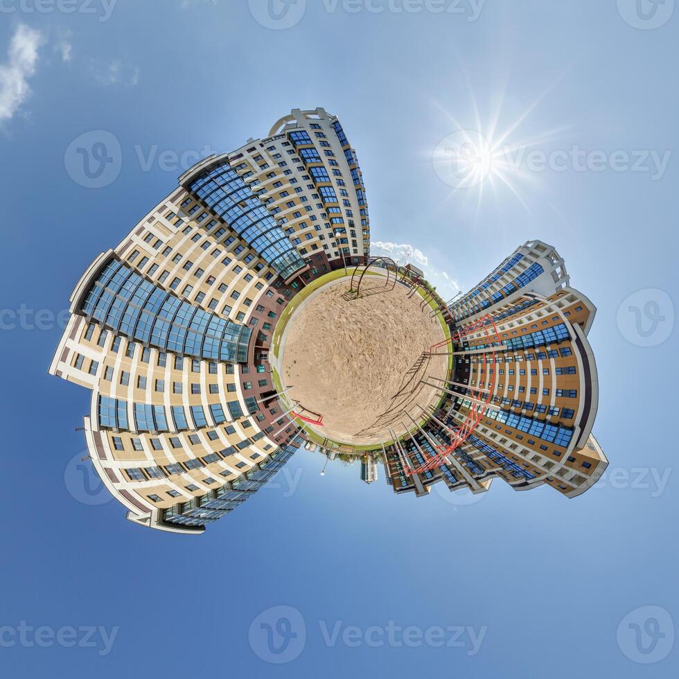 abstract swirling tiny planet spherical panorama of multi-storey buildings of skyscrapers of a residential complex in the form of a butterfly in blue sky photo