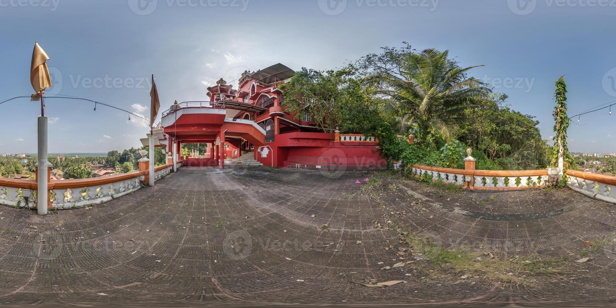 full hdri 360 panorama near hindu maruti temple of ape goddess hanuman on high mountain in jungle among palm trees in Indian tropic town in red color in equirectangular projection. VR AR content photo