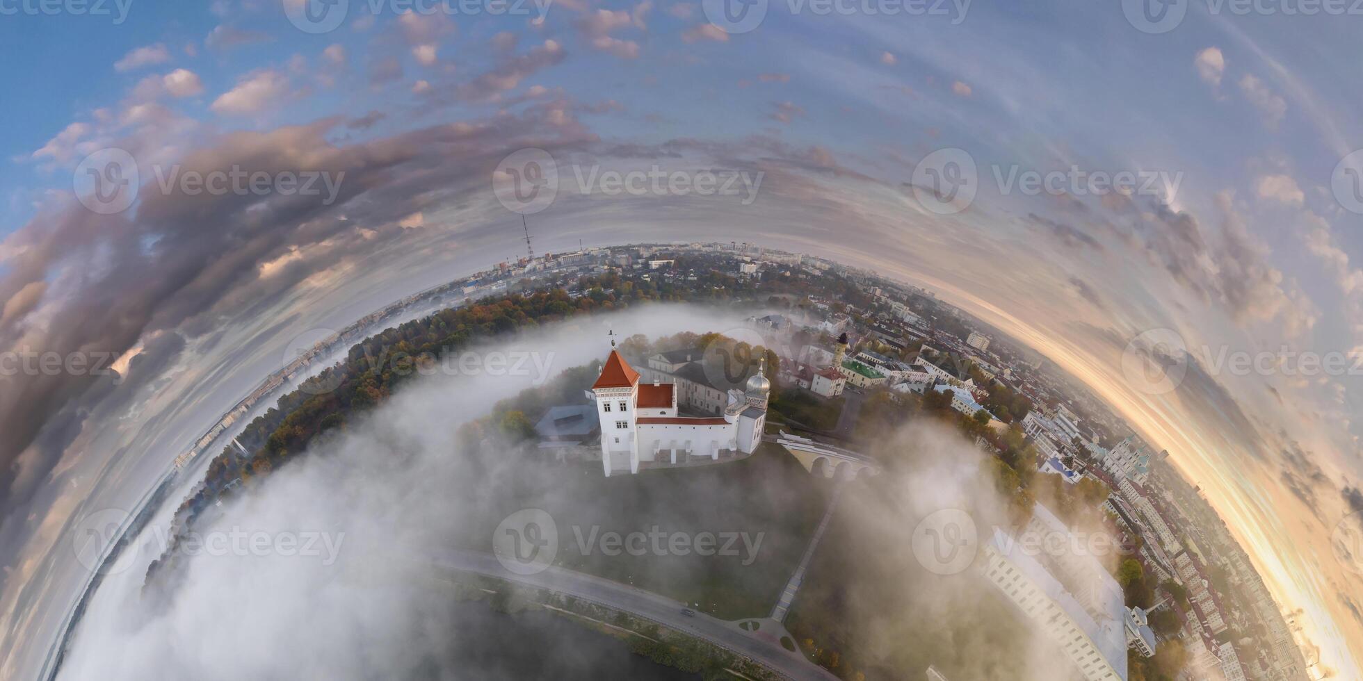 Aerial view from high altitude tiny planet in morning sky with clouds overlooking old town with castle in fog. Transformation of spherical 360 panorama in abstract aerial view. photo