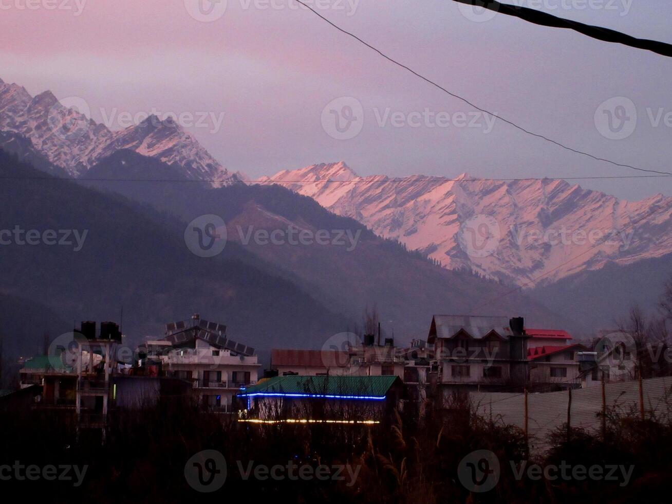Pink Sky with snow-covered mountains Glacier and tall trees in Himachal Pradesh India photo