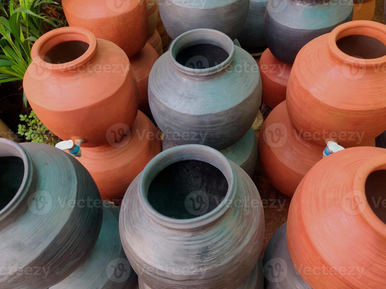 A clay water pot earthen pot with tap for water storage Clay pots not only cool the water down, they also provide healing with the elements of earth. photo