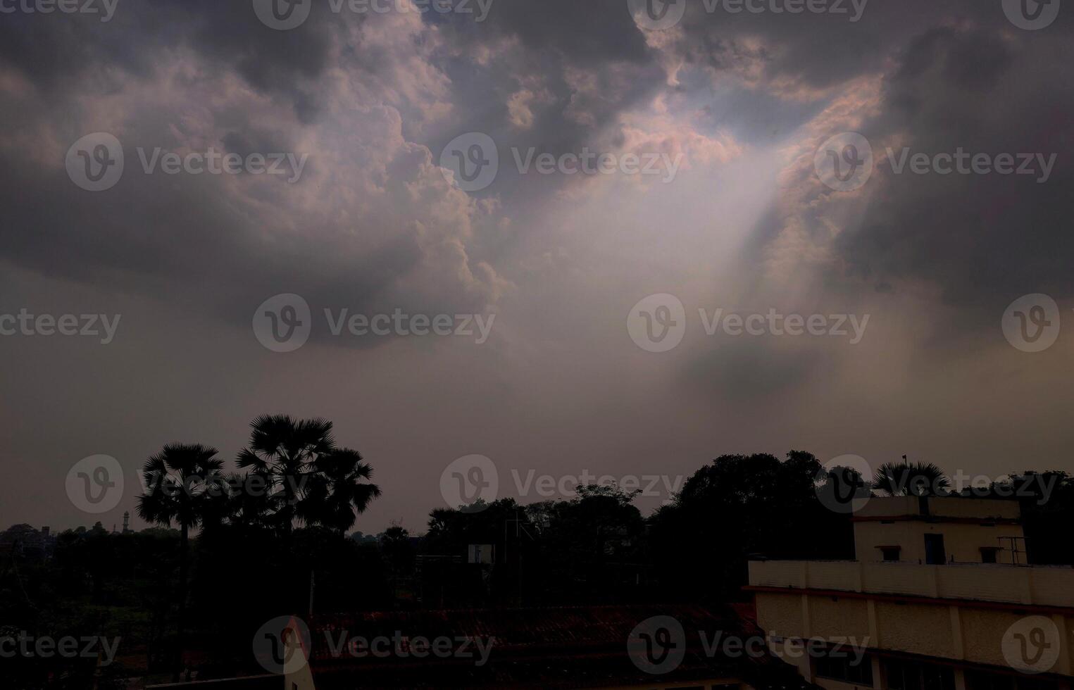 Sparkling beams of light extending from clouds during the rainy season in an Indian villgae photo