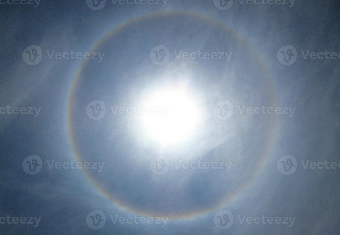 A 360-degree rainbow formed around the sun during midday as seen from ground photo