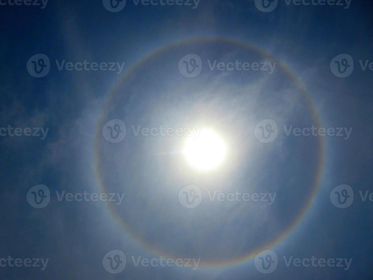 A 360-degree rainbow formed around the sun during midday as seen from ground photo