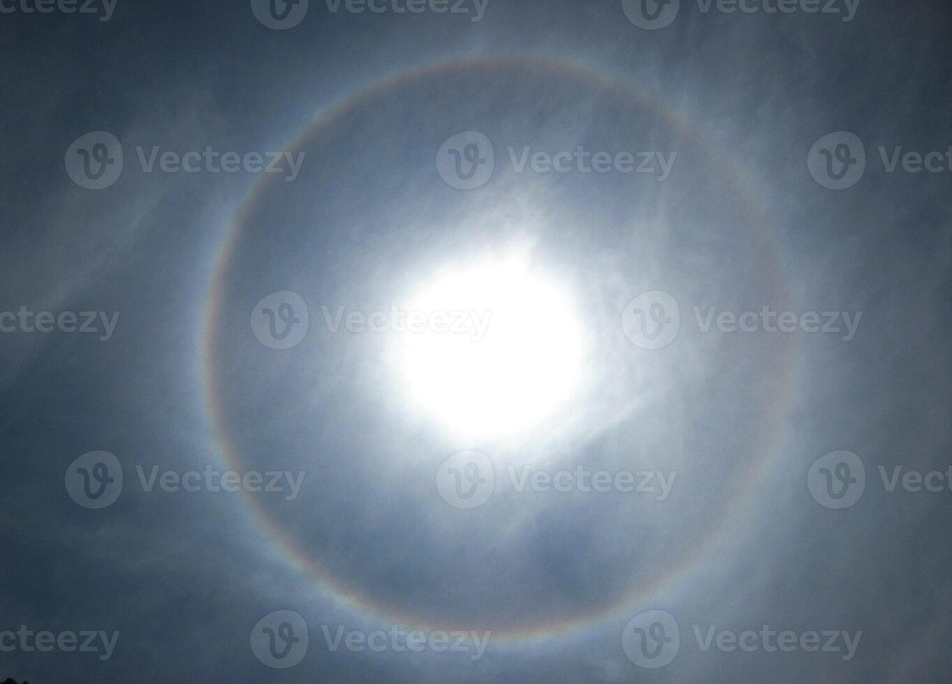 A 360-degree rainbow formed around the sun during midday as seen from ground photo