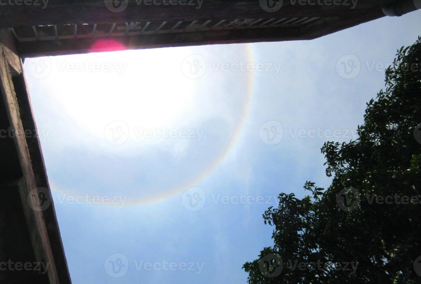 A 360-degree rainbow formed around the sun during midday as seen from ground photo