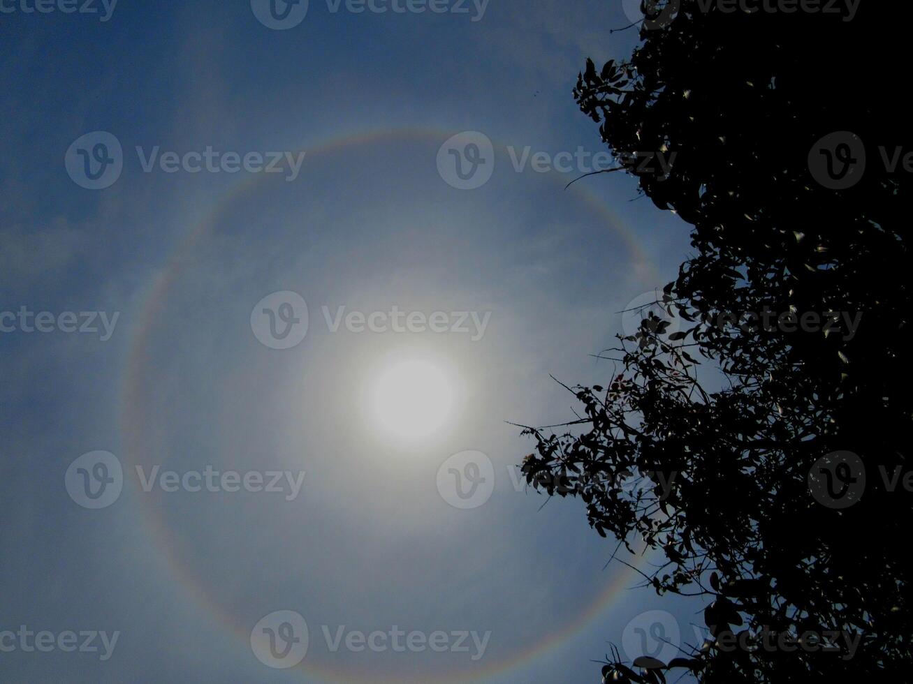 A 360-degree rainbow formed around the sun during midday as seen from ground photo
