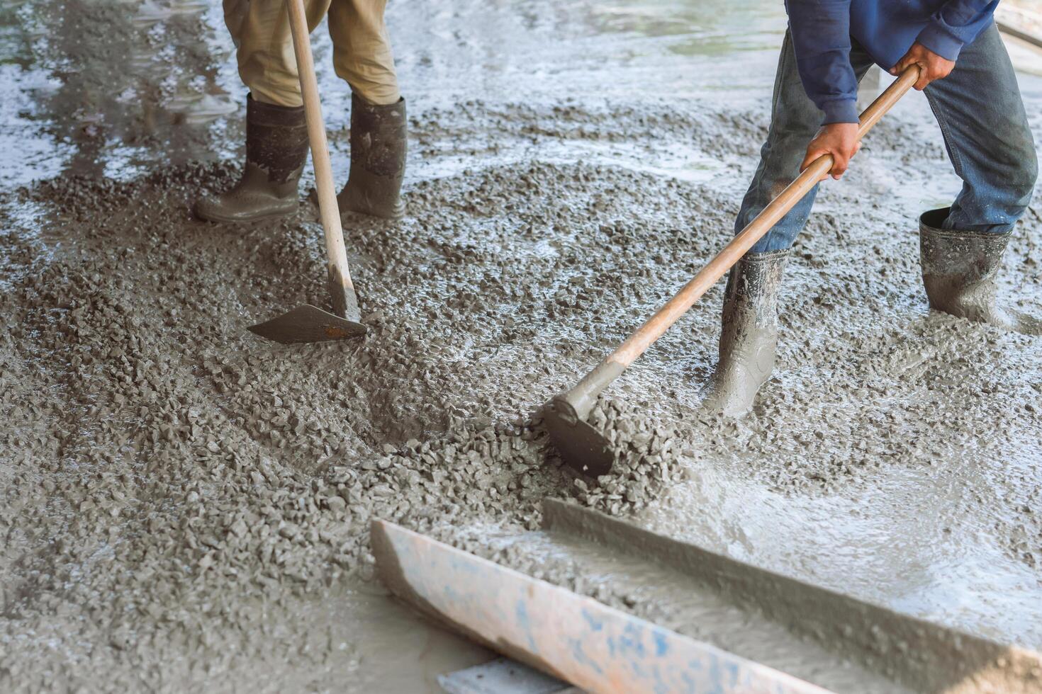 Two men are working on a concrete slab photo