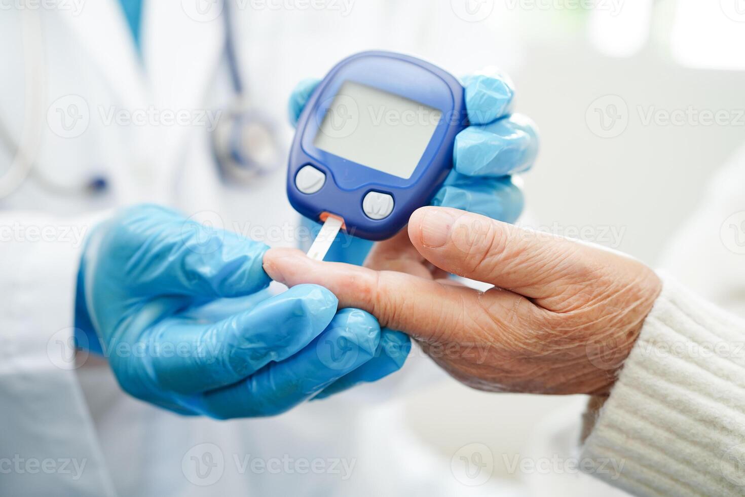 Asian doctor using digital glucose meter for check sample blood sugar