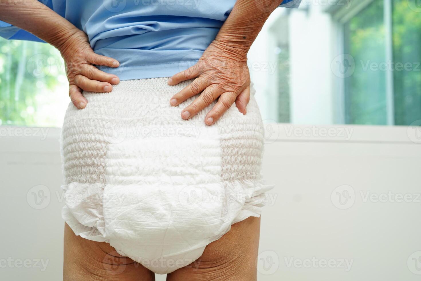 Asian senior woman patient wearing adult incontinence diaper pad in hospital. photo