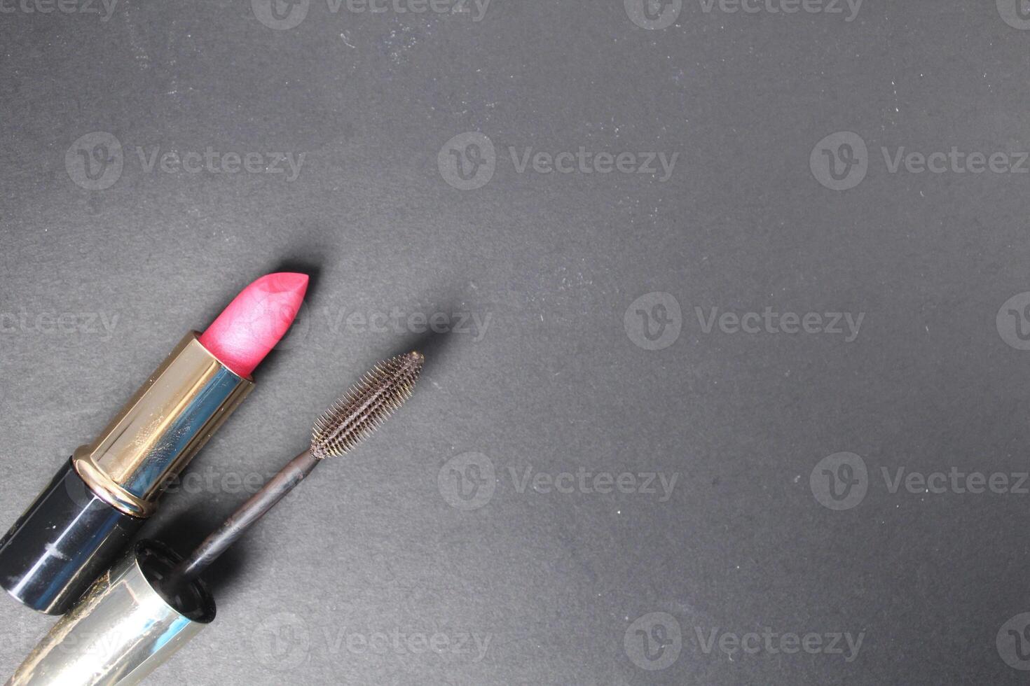 Red pink lipstick and mascara on a black background with space for the text moka copyspace. How to Wear Makeup for Every Day photo