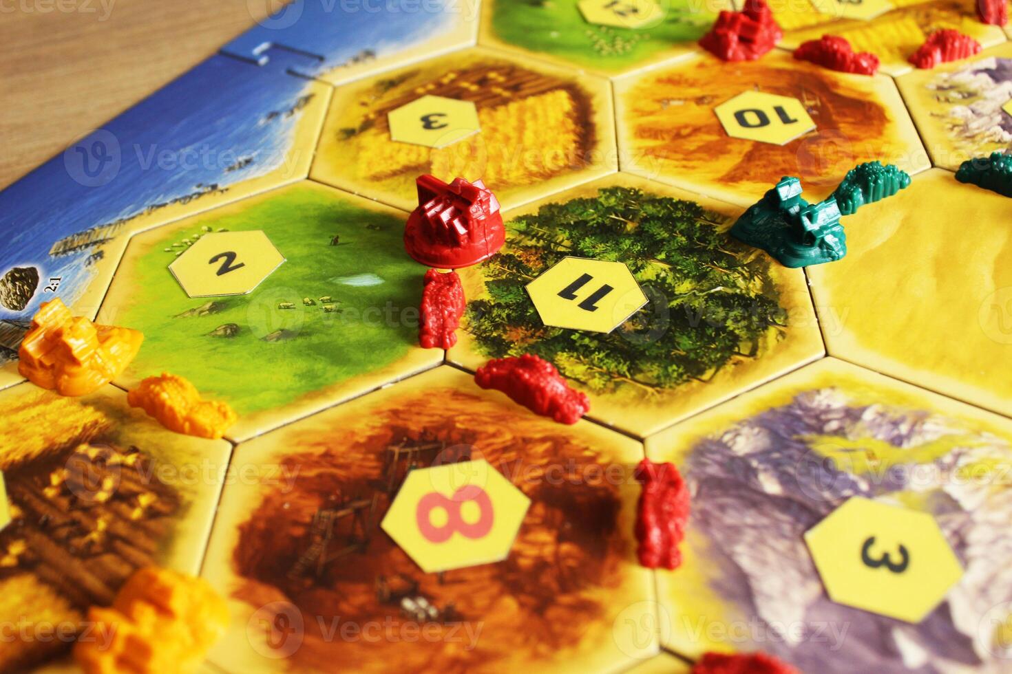 Mozyr, Belarus, April 01 2024. A catan board game green, red and green chips of players on the map. Red and black numbers on the map. Good and Bad Hexes photo