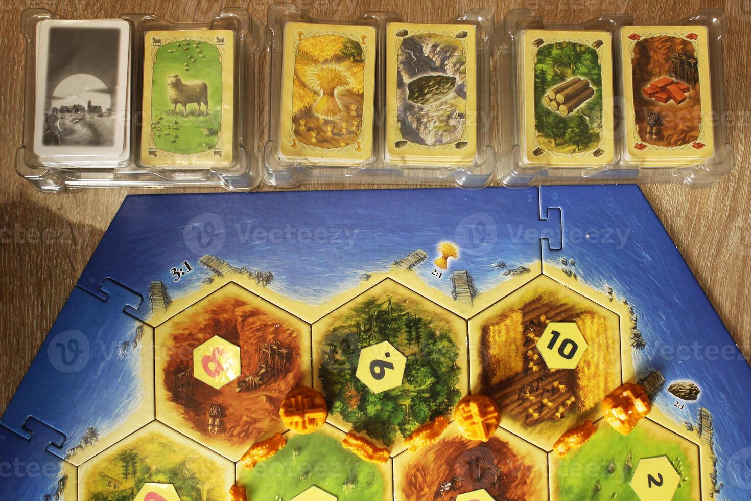 Mozyr, Belarus, April 01 2024. A catan board game preparation for the game. Resource map layout and development map top view. Getting Started photo