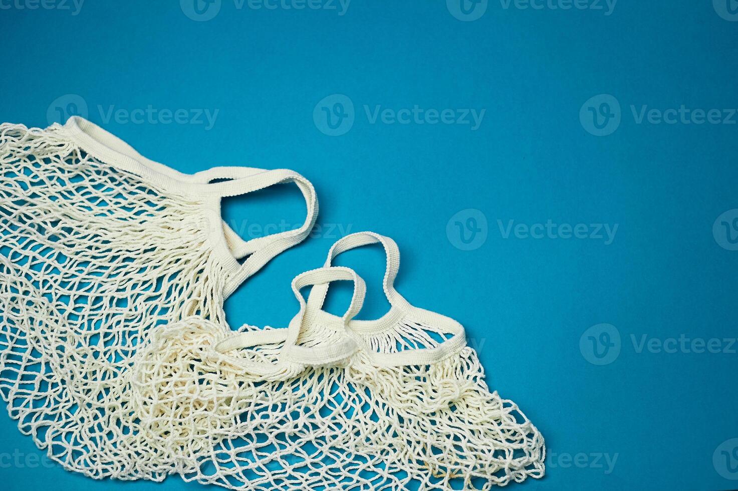 Replacing plastic bags.Taking care of the environment. Empty mesh, awosika on a blue background. photo