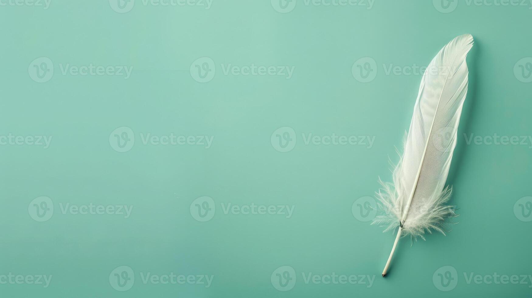 Elegant feather quill pen on a serene mint green background, ideal for creative copyspace photo