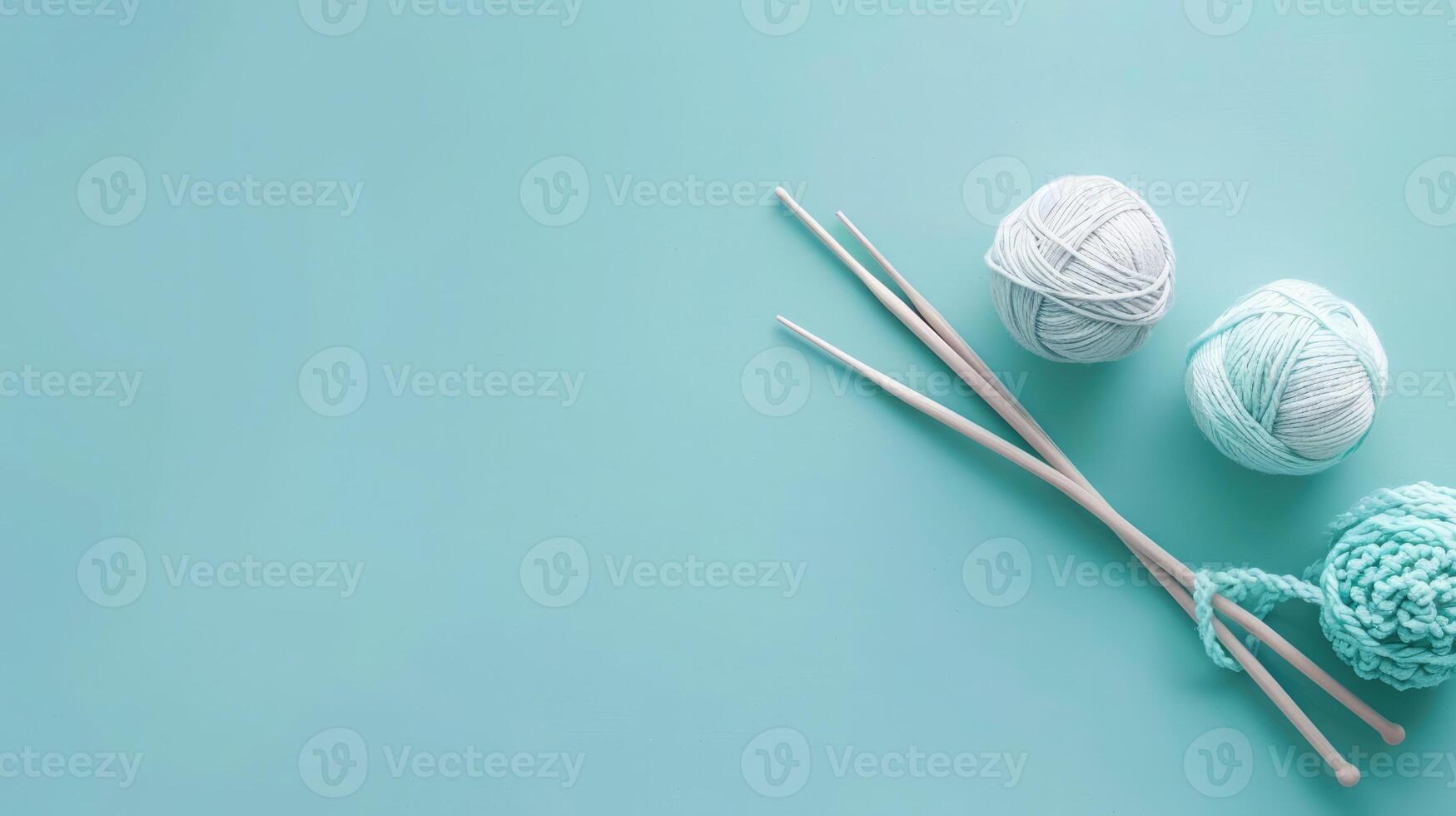 Soft blue background featuring a pair of knitting needles with yarn and generous copyspace for text photo