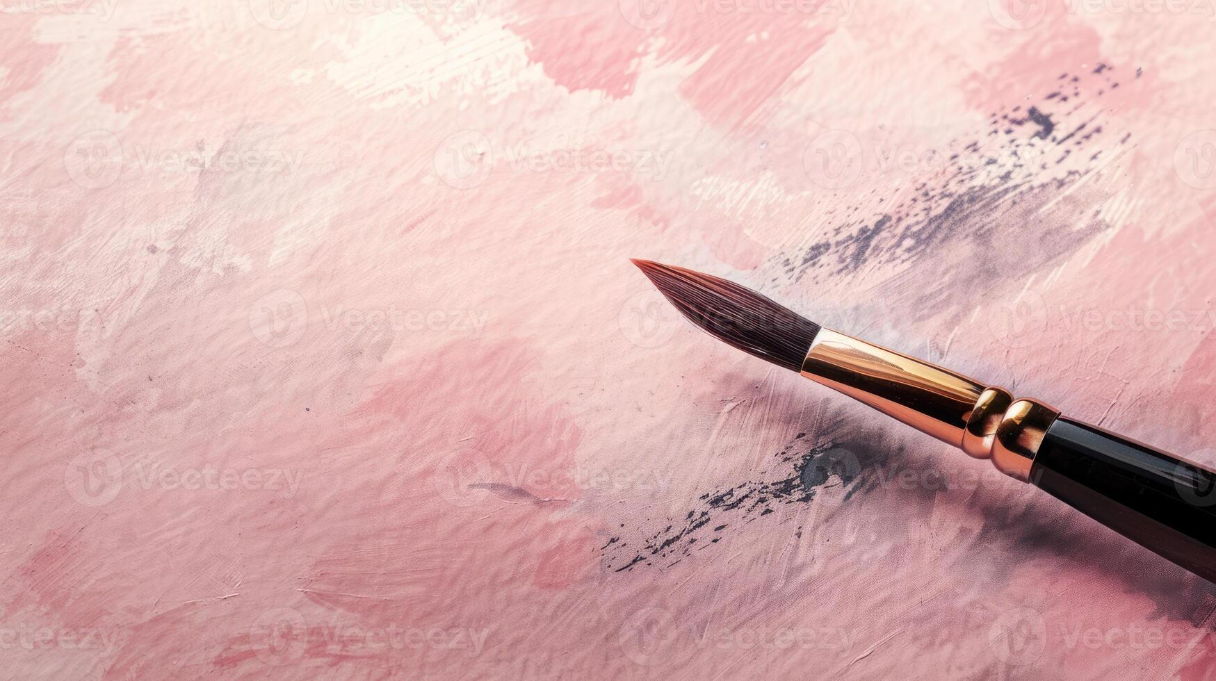 Artistic calligraphy brush on a dusty rose background with generous copyspace photo