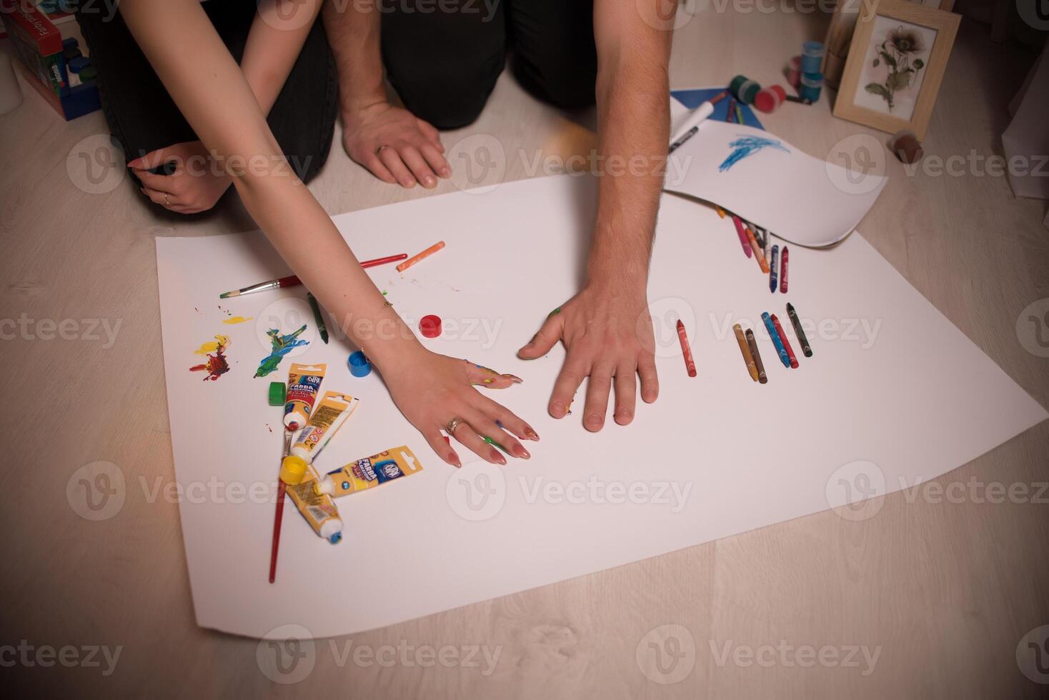 Two lovers draw with paints. Two lovers draw with paints. Hands are covered with paint . photo