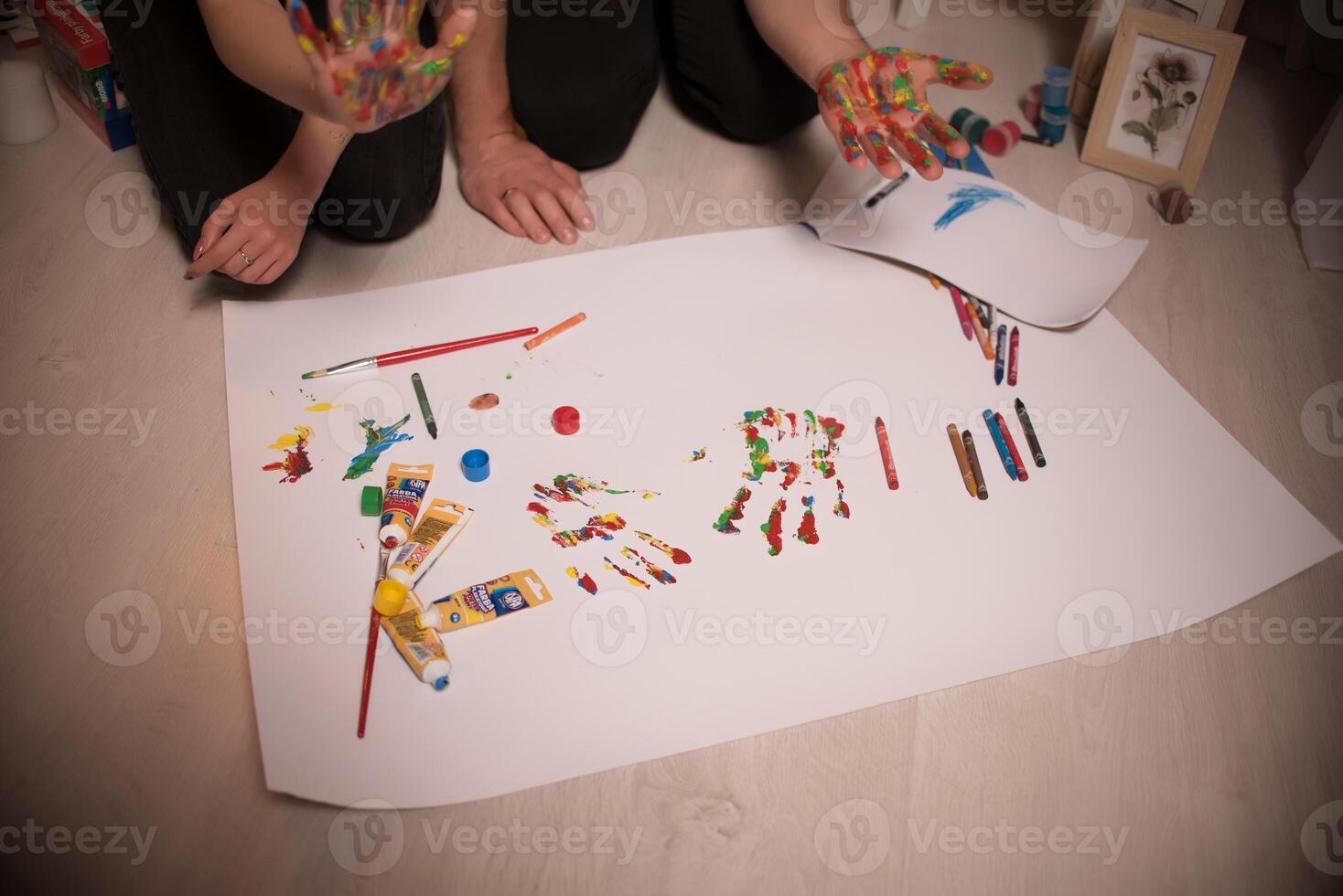Two lovers draw with paints. Two lovers draw with paints. Hands are covered with paint . photo