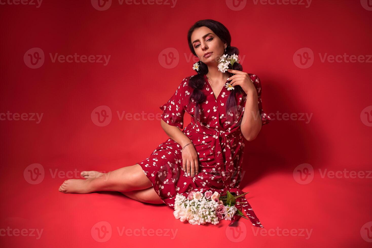 beautiful girl in a red dress on a red background with flowers photo
