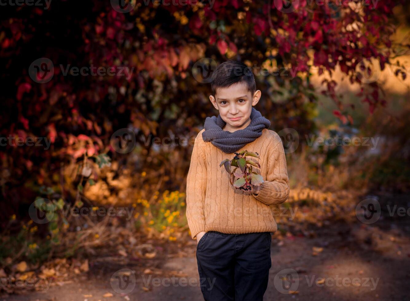 Handsome stylish boy standing in autumn park photo