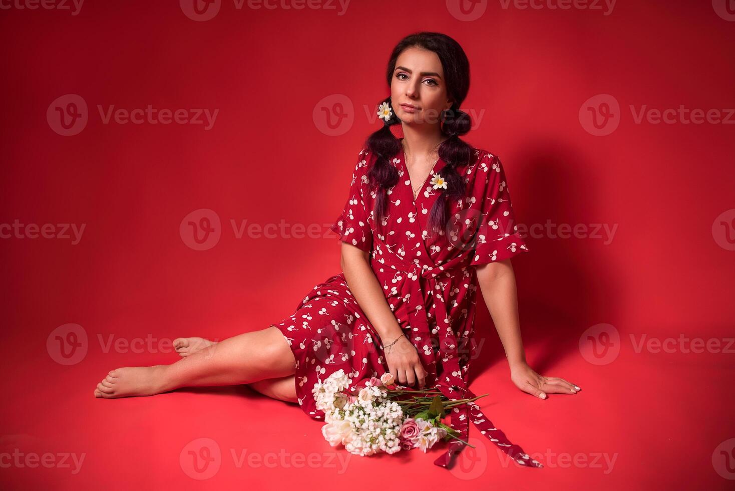 beautiful girl in a red dress on a red background with flowers photo