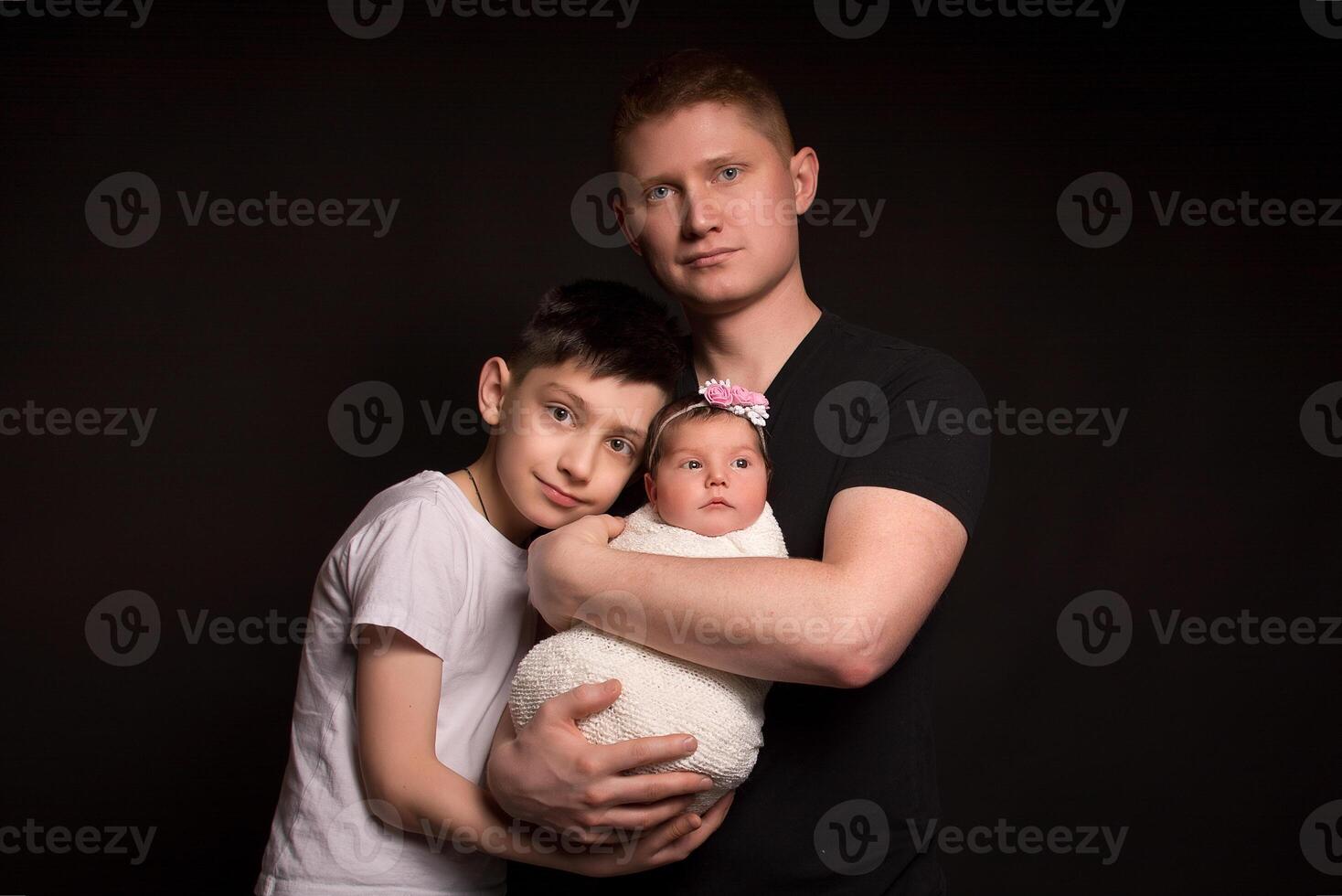 Dad, son and daughter. Close-up . Black background . photo