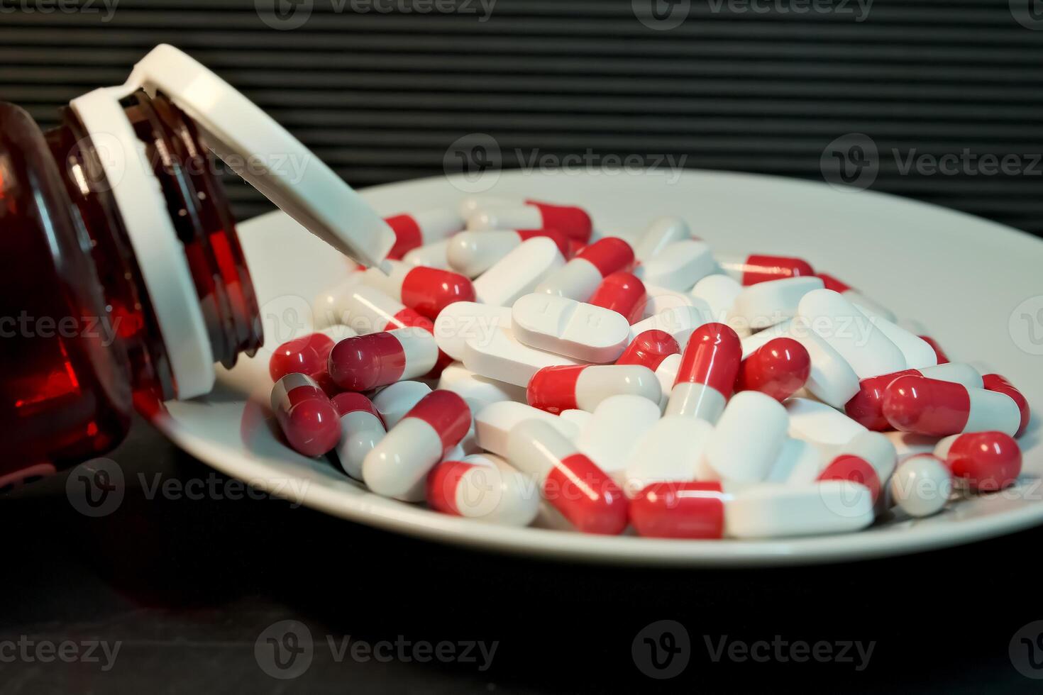 white and red pills in a plate. close-up. the concept of health, treatment. photo