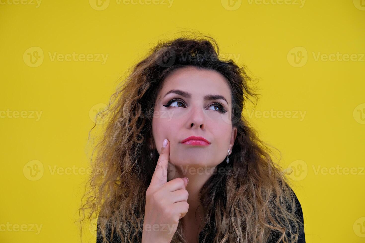 Close-up portrait of a beautiful girl on a yellow background. woman shows thoughtfulness. human emotions photo