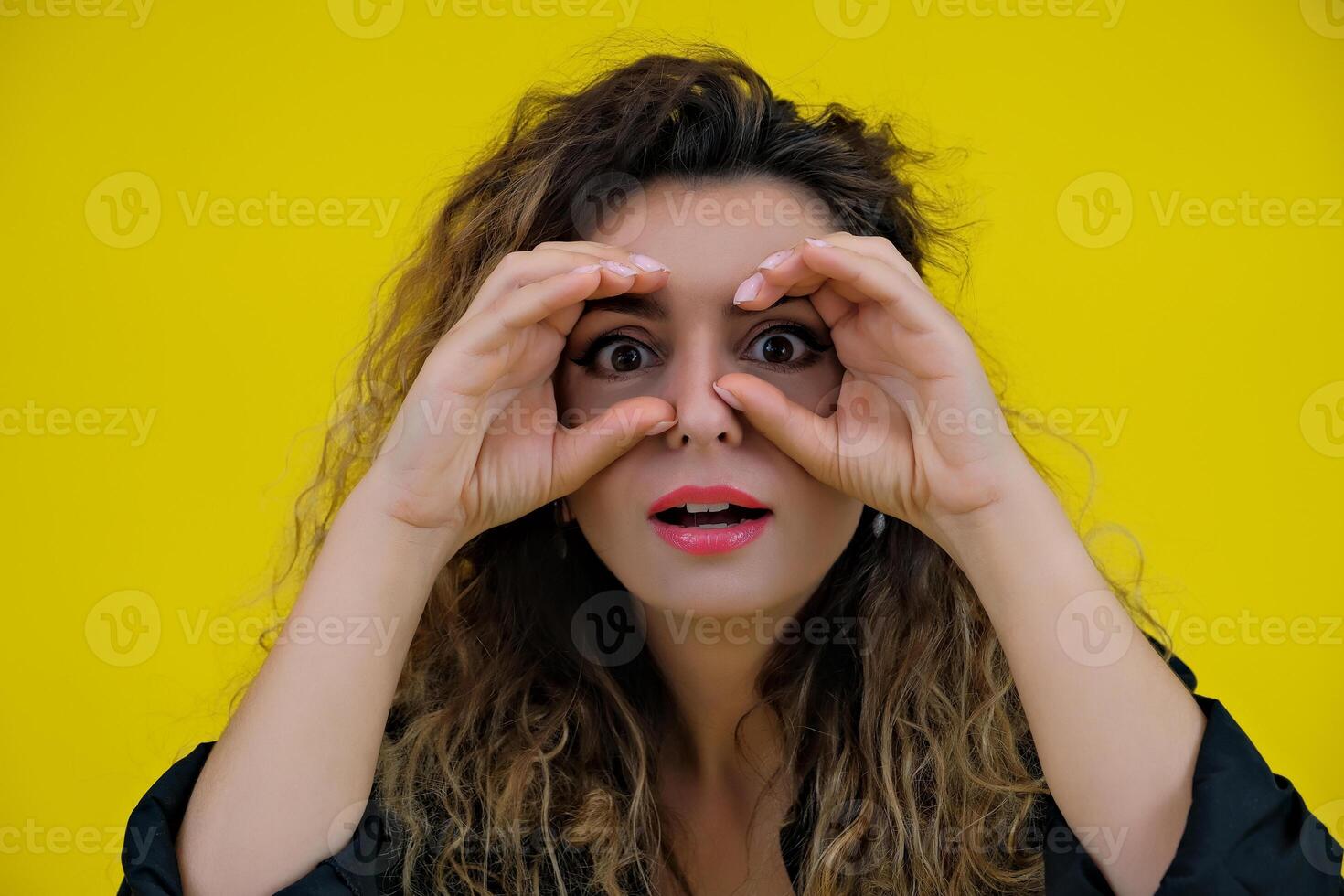 Close-up portrait of a beautiful girl on a yellow background. woman looks out for advertising space, advertises copy space photo