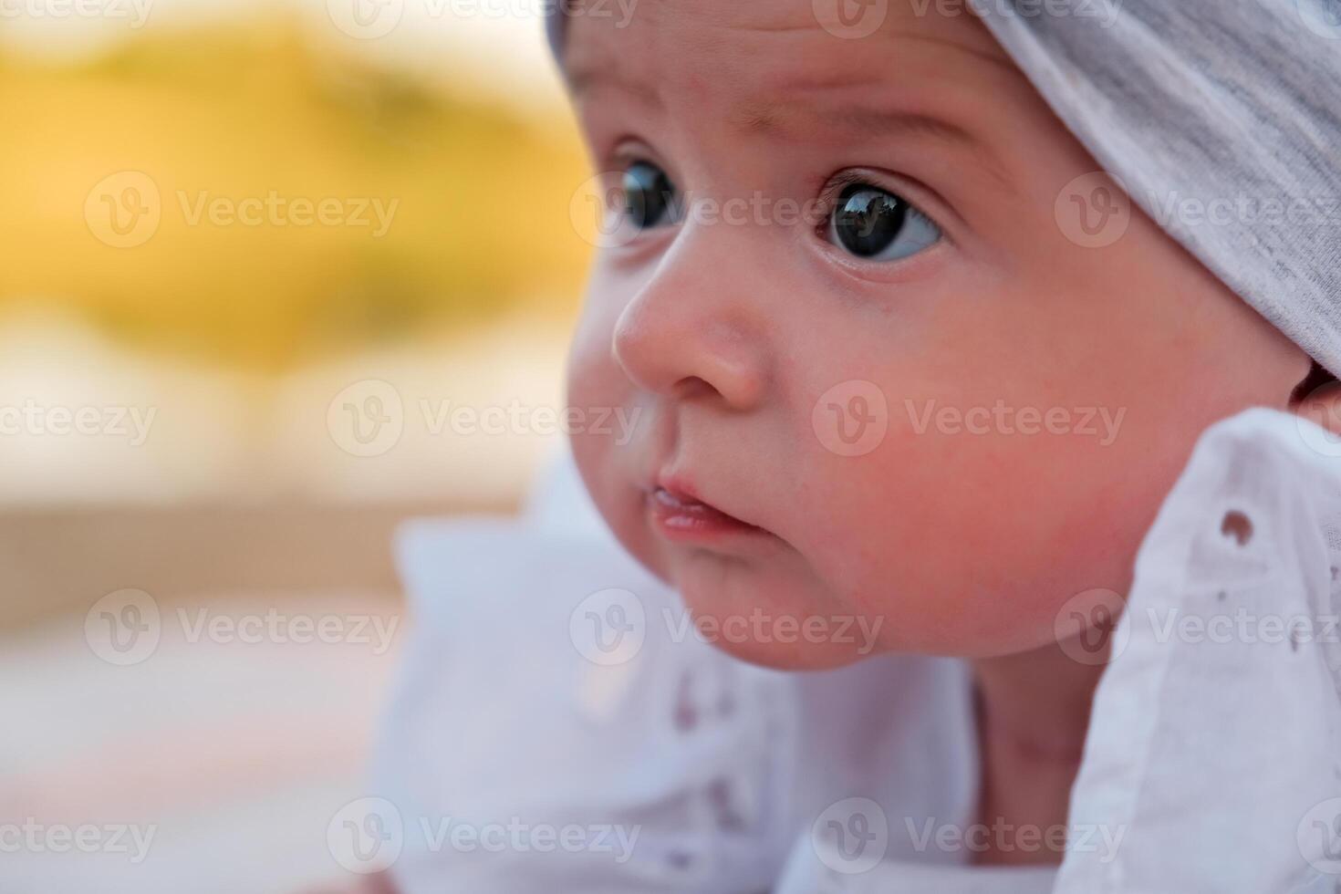 newborn baby girl lies on the beach. in a white dress. photo