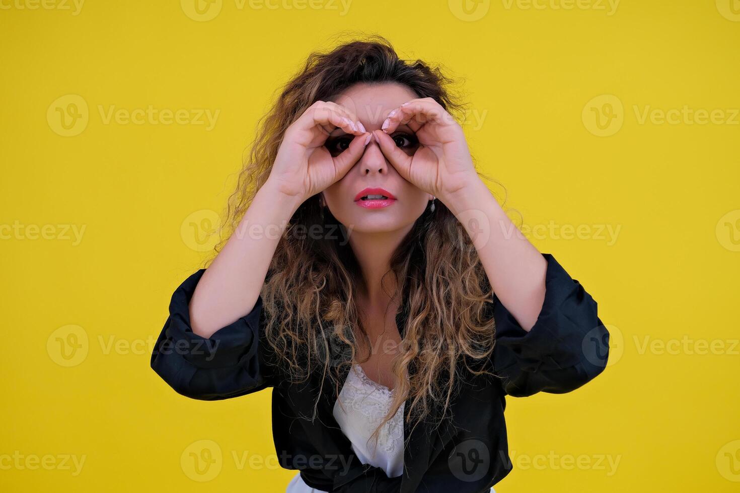 Close-up portrait of a beautiful girl on a yellow background. woman looks out for advertising space, advertises copy space photo