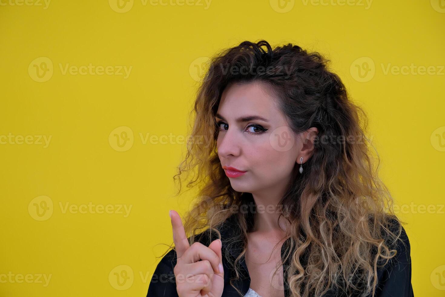 Close-up portrait of a beautiful girl on a yellow background. woman shows stop, prohibition. human emotions photo