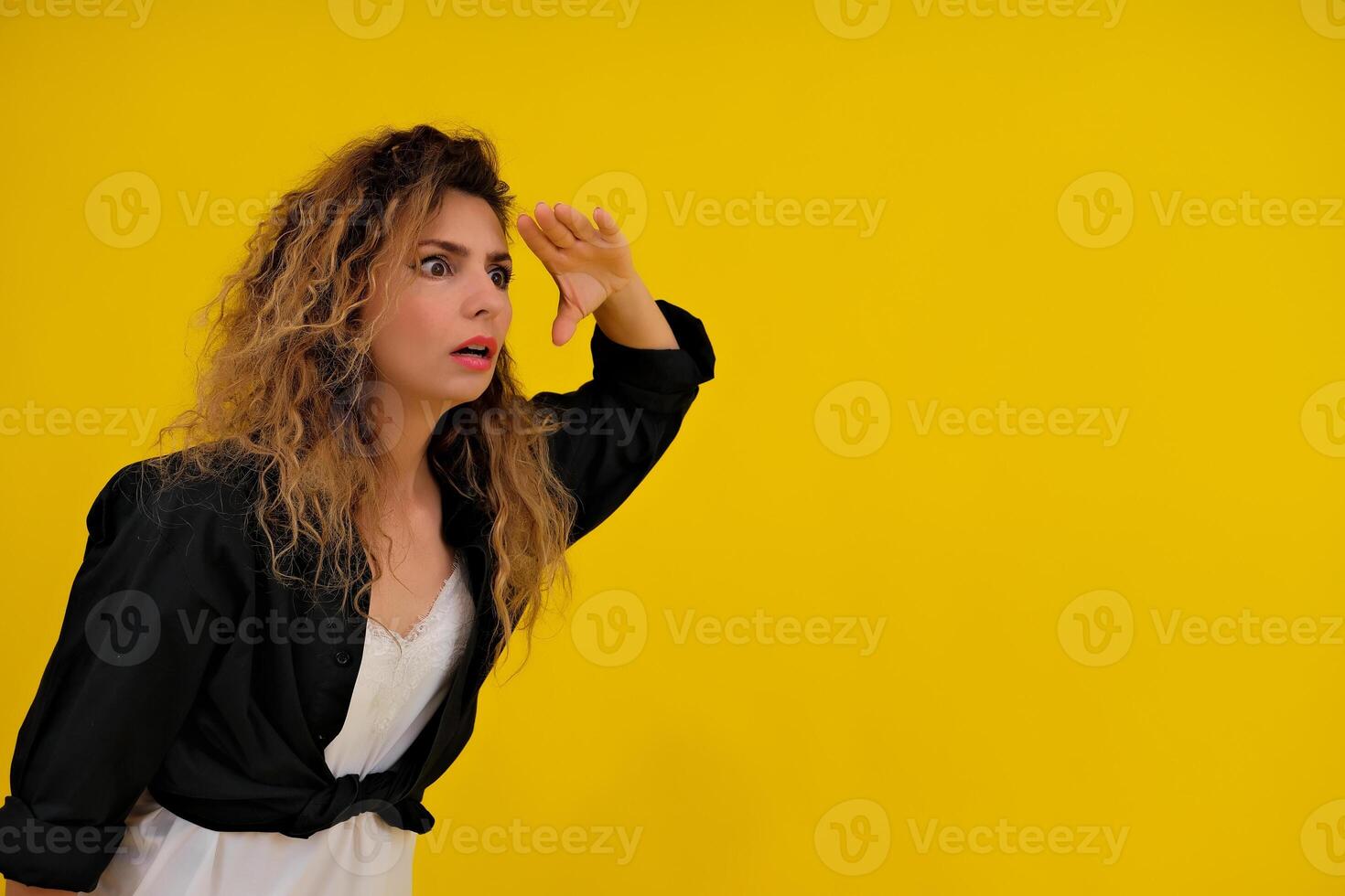 Close-up portrait of a beautiful girl on a yellow background. woman looks out for advertising space, advertises copy space photo